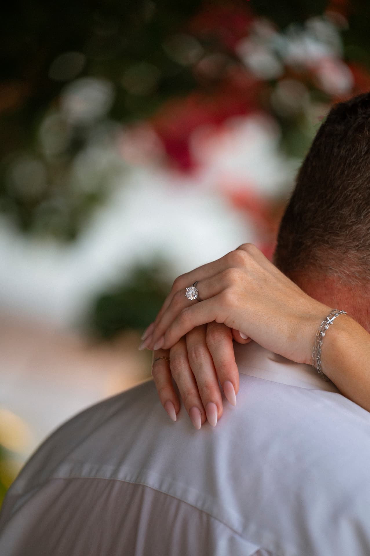 Her hands clasped behind his neck showing the engagement ring after a proposal in Puerto Vallarta